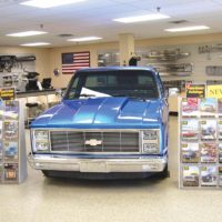 Chevy truck in retail store is surrounded by the two dozen truck parts catalogues LMC sends out for free.